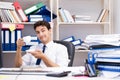 Businessman working in the office with piles of books and papers Royalty Free Stock Photo