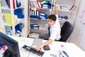 Businessman working in the office with piles of books and papers Royalty Free Stock Photo