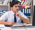 Businessman working in the office with piles of books and papers Royalty Free Stock Photo