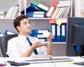 Businessman working in the office with piles of books and papers Royalty Free Stock Photo