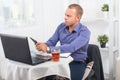 Businessman working in office, sitting at table with a laptop