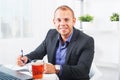 Businessman working in office, sitting at table with a laptop, looking smiling Royalty Free Stock Photo