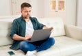 Businessman working online sitting on couch.