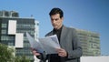 Businessman working with papers on street. Entrepreneur reading documents