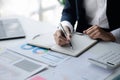 Businessman working in a private office, she is reviewing the company's financial documents sent from the finance department