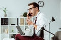 businessman working with smartphone and laptop while eating takeout noodles for lunch Royalty Free Stock Photo