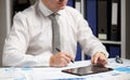 Businessman working with tablet pc, calculating, reading and writing reports. Office employee, table closeup. Business financial Royalty Free Stock Photo