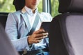 A man works with a tablet in the back seat of a car Royalty Free Stock Photo