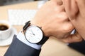 Businessman with wrist watch working at office table, closeup. Royalty Free Stock Photo