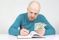 Businessman writes down his financial income in a notebook