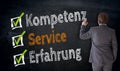 Businessman writes Kompetenz, Service, Erfahrung & x28;in german comp