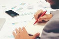 Businessman writing a business report on blank notebook with red pen on desk office. .Business concept: Royalty Free Stock Photo