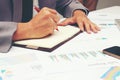 Businessman writing a business report on blank notebook with red pen on desk office. .Business concept: Royalty Free Stock Photo