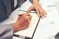 Businessman writing a business report on blank notebook with red pen on desk office. .Business concept: Royalty Free Stock Photo