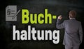 Businessman is writing with chalk Buchhaltung in german accounting on blackboard Royalty Free Stock Photo