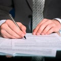 Businessman writing on a form