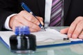 Businessman Writing With Ink Pen Royalty Free Stock Photo