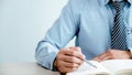 Businessman writing on note book at the home office for setting challenging business goals And planning to achieve the new target