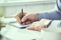 Businessman writing note on a notebook close-up. Business man working at office desk. Close up of empty notebook on a Royalty Free Stock Photo