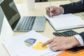 Businessman writing note on notebook and use laptop Royalty Free Stock Photo