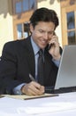 Businessman Writing Notes While On Call Royalty Free Stock Photo