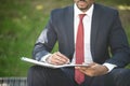 Businessman writing notes while sitting on a bench Royalty Free Stock Photo