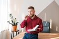 Businessman writing notes while sitting at his desk. Young bearded man Royalty Free Stock Photo