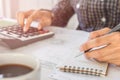 Businessman Writing paper and using calculator Calculating bonusOr other compensation to employees to increase productivity. on Royalty Free Stock Photo