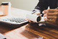 Businessman Writing paper and using calculator Calculating bonusOr other compensation to employees to increase productivity. on Royalty Free Stock Photo