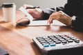 Businessman Writing paper and using calculator Calculating bonusOr other compensation to employees to increase productivity. on Royalty Free Stock Photo