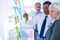 Businessman writing on post it with his colleagues Royalty Free Stock Photo