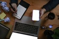 Businessman writing something on notepad and using smart phone. Royalty Free Stock Photo