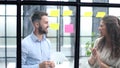 Businessman writing sticking adhesive notes on glass wall in office and team help to creative idea, Teamwork working Royalty Free Stock Photo