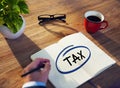 Businessman Writing the Word Tax on Note Pad Royalty Free Stock Photo