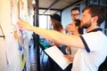 Businessman with young partners looking at whiteboard in creative office. Royalty Free Stock Photo