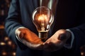 A businessmans hand cradles a glowing light bulb, embodying inspiration