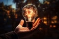 In a businessmans hand, a radiant light bulb sparks innovation Royalty Free Stock Photo