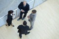 Businessmen and businesswoman standing together by railing