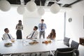 Businessmen And Businesswomen Meeting In Modern Boardroom Over Working Lunch Royalty Free Stock Photo