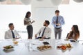 Businessmen And Businesswomen Meeting In Modern Boardroom Over Working Lunch Royalty Free Stock Photo