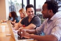 Businessmen And Businesswomen Working In Shared Open Plan Office Workspace