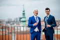 Businessmen with champagne standing outdoors on roof terrace in city. Royalty Free Stock Photo