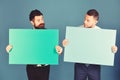 Businessmen with curious faces present green and pink sign boards