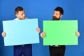 Businessmen with curious faces present green and pink sign boards