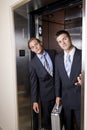 Businessmen in elevator looking out doorway