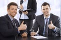 Businessmen giving the thumbs up, smiling Royalty Free Stock Photo