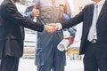 Businessmen handshake with engineer thumbs up