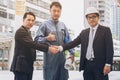 Businessmen handshake with engineer thumbs up