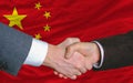 Businessmen handshake in front of china flag