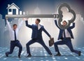 Businessmen holding giant key in real estate concept Royalty Free Stock Photo